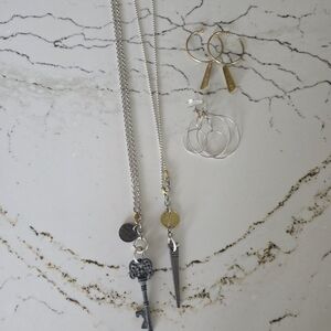 Two Twisted Silver Necklaces And Two Sets Of Hoop Earrings.